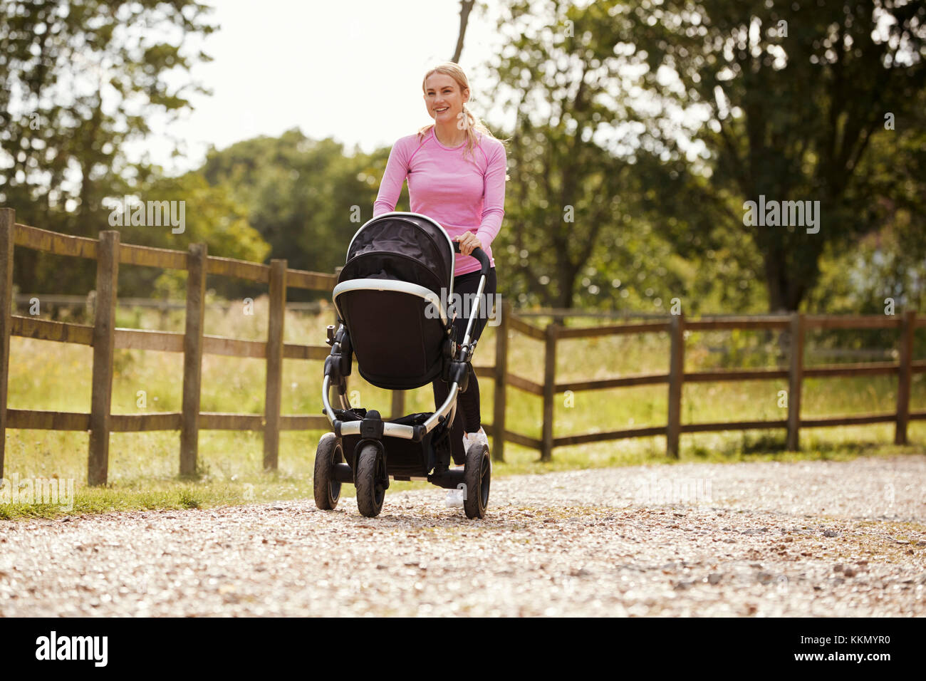 Madre esercita eseguendo Premendo Baby Buggy Foto Stock