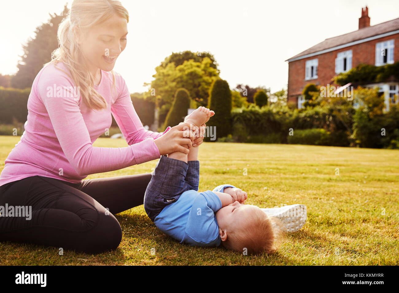 Madre giocare in giardino con Baby figlio Foto Stock