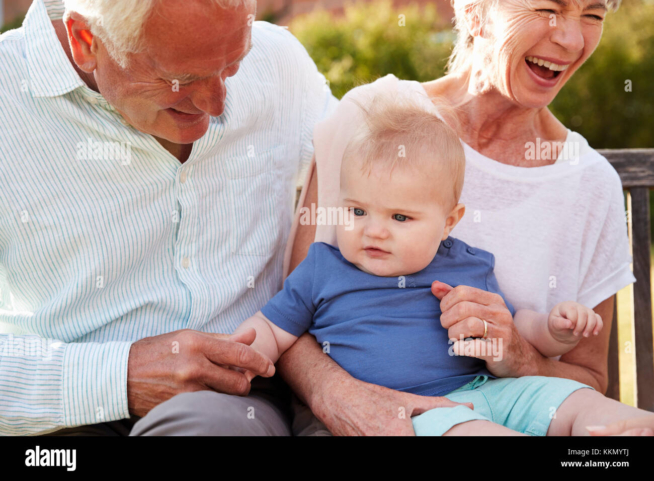 Nonni seduto sul sedile in giardino con Baby nipote Foto Stock