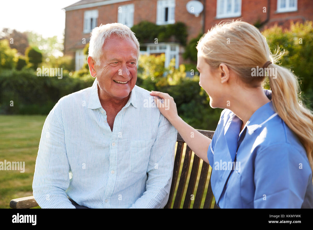 Infermiere parlando a Senior uomo In Assistenza Residenziale Home Foto Stock