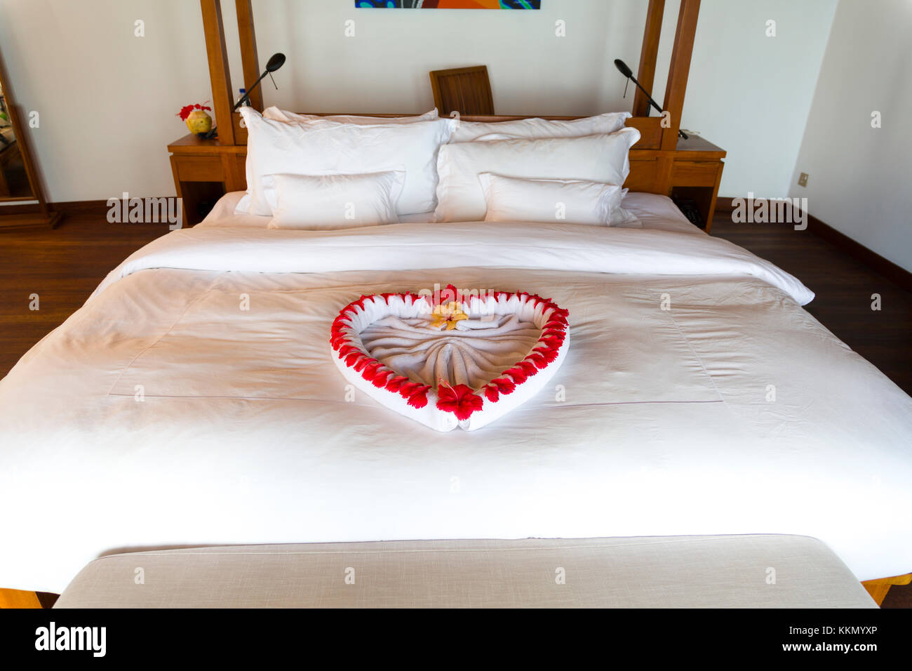 Asciugamano forma un bel cuore decorato con fiori di colore rosso in un  Resort di lusso