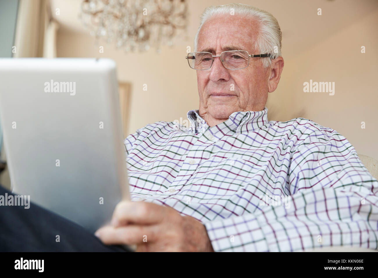 Senior uomo che utilizza un computer tablet a casa, close up Foto Stock