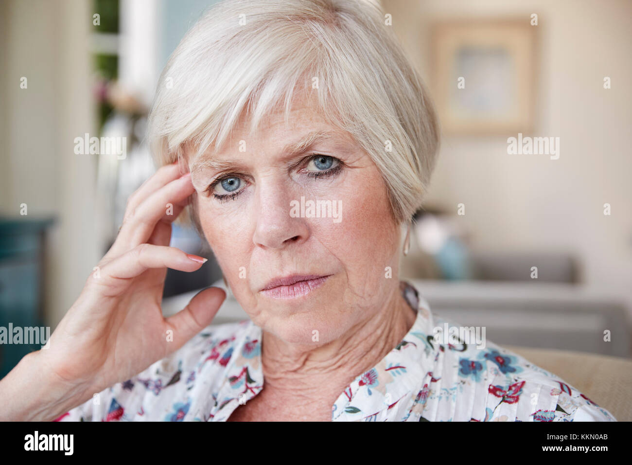 Grave senior donna che guarda alla telecamera a casa, close up Foto Stock