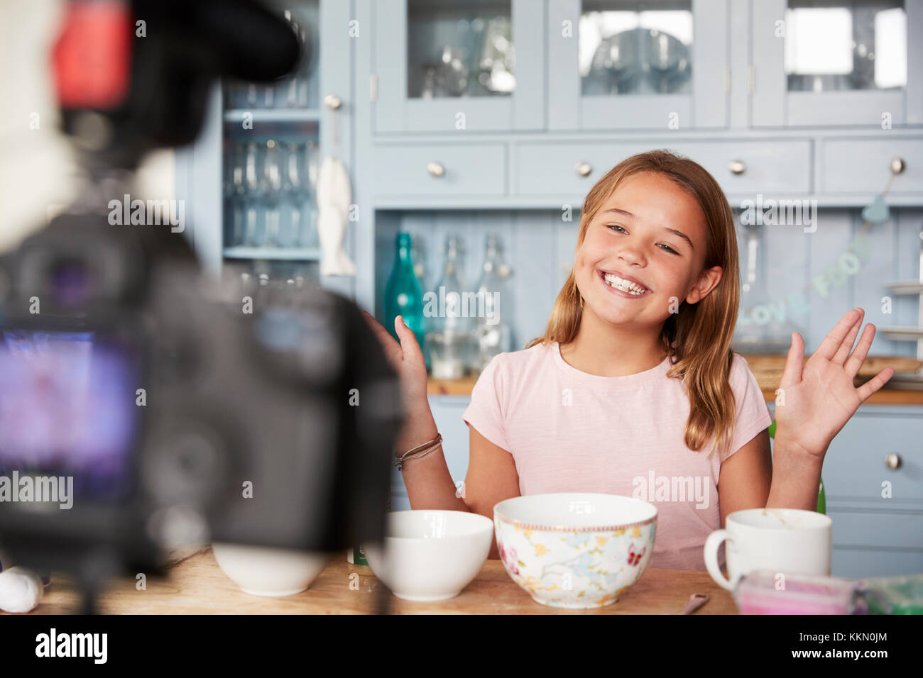Pre-teen girl blog video in cucina sventolare le mani Foto Stock