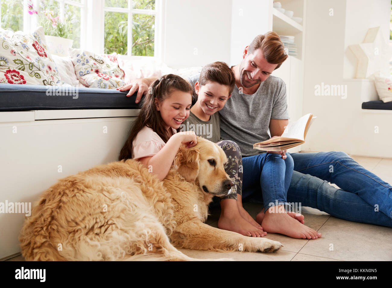 Padre Libro di lettura con il Figlio e la figlia e il cane a casa Foto Stock