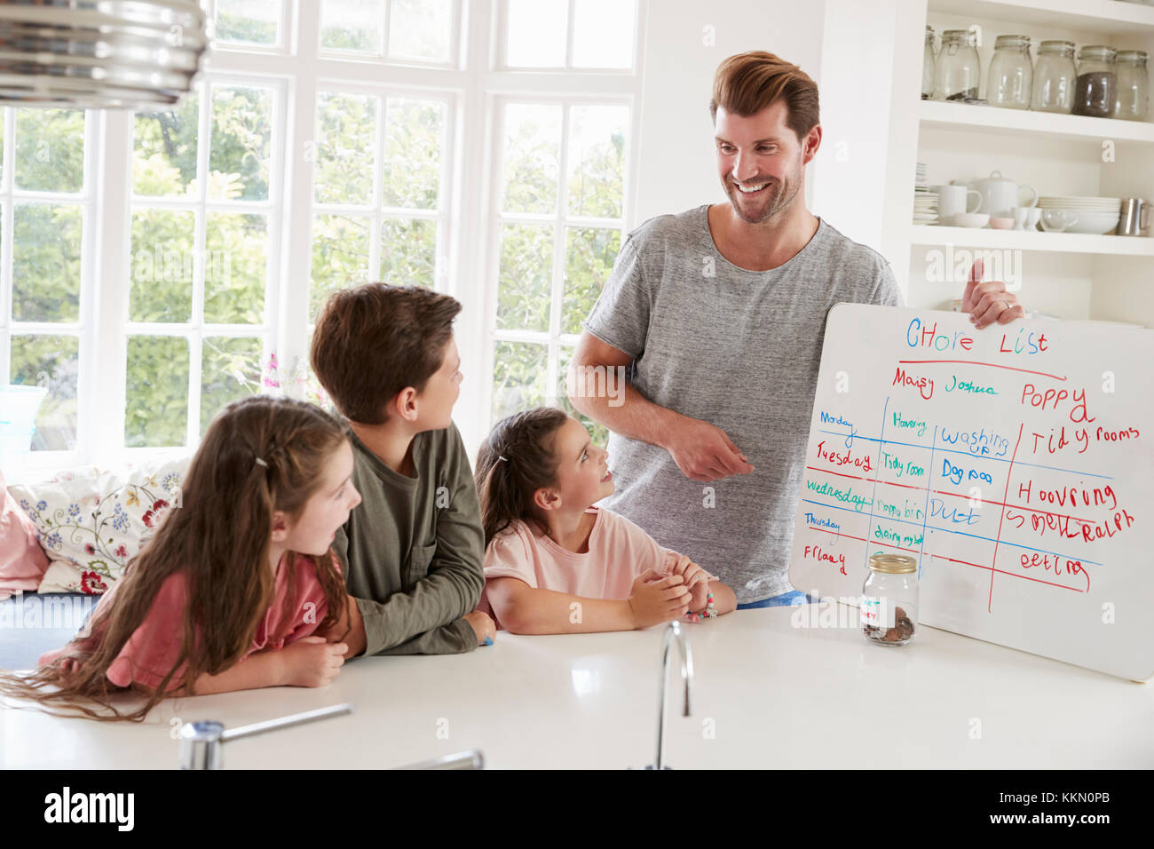 I bambini che ricevono denaro in tasca dopo aver completato la lista delle attività da fare Foto Stock