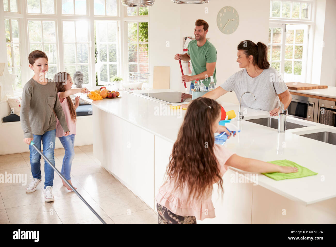 I bambini aiutano i genitori con mansioni domestiche in cucina Foto Stock