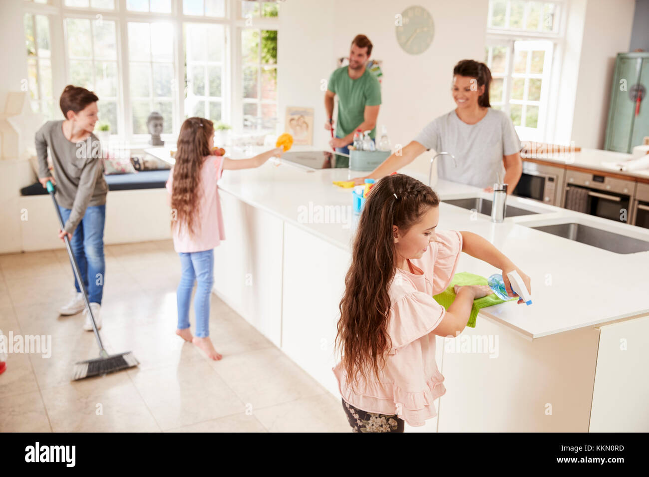 I bambini aiutano i genitori con mansioni domestiche in cucina Foto Stock