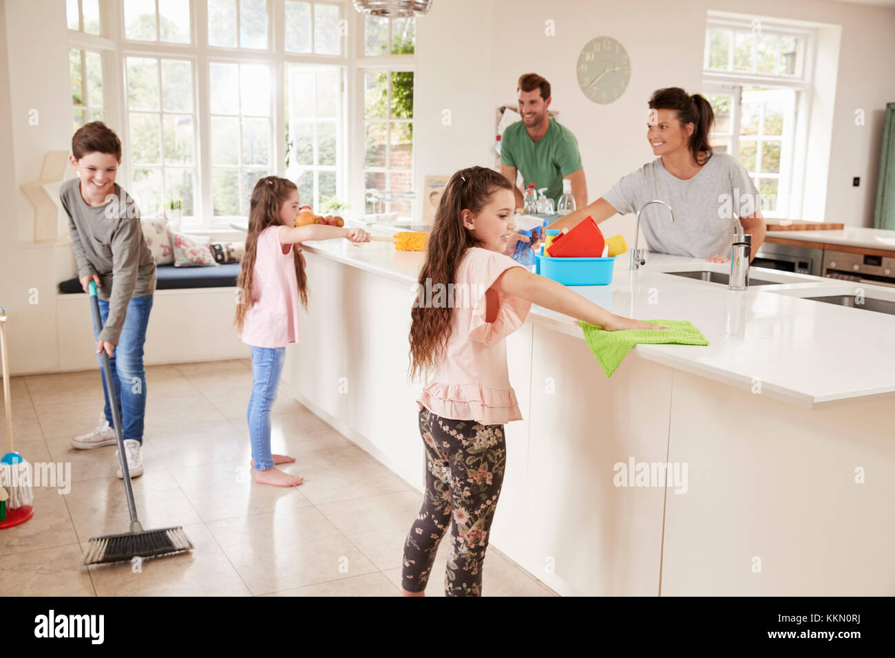 I bambini aiutano i genitori con mansioni domestiche in cucina Foto Stock