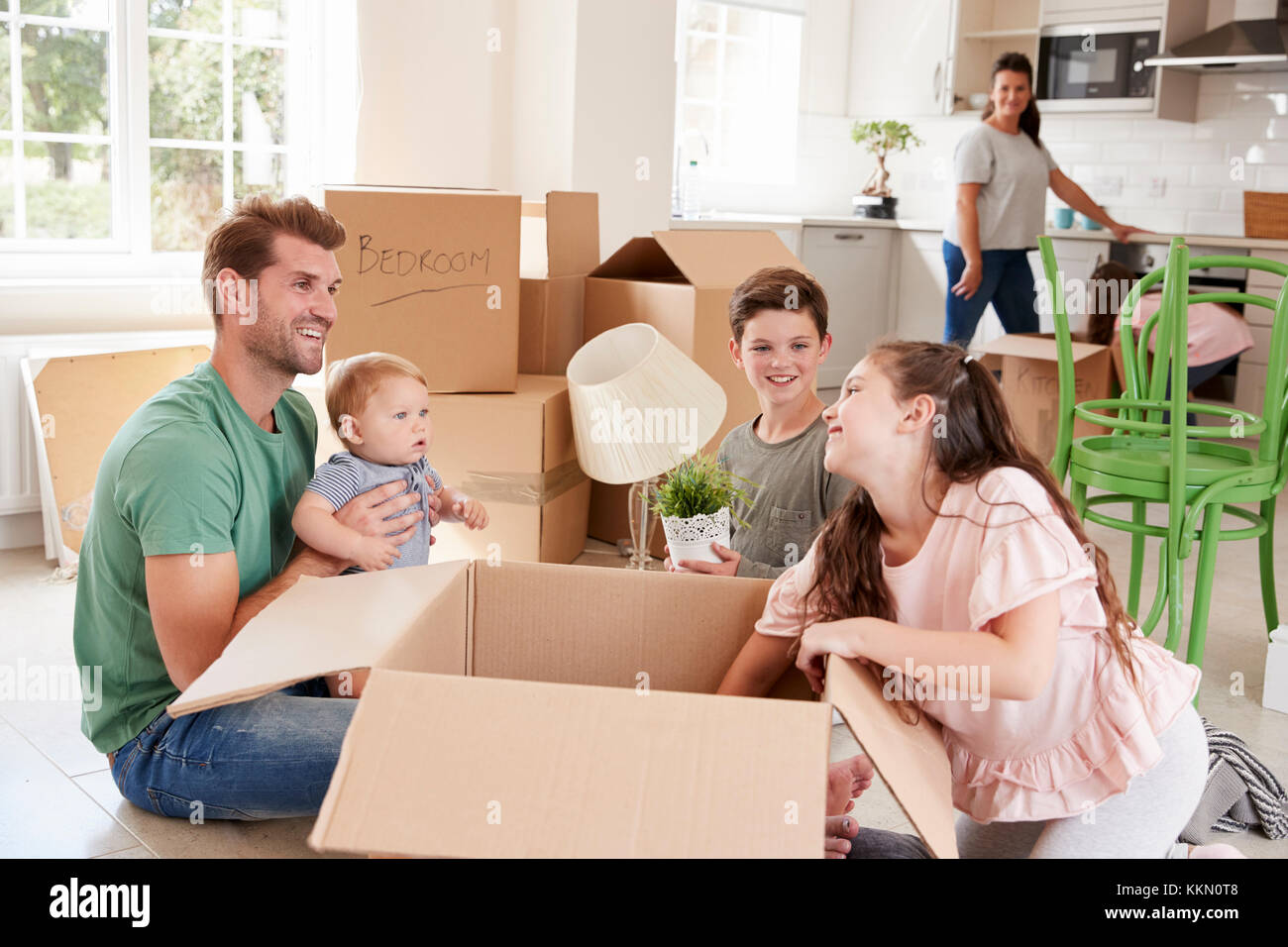 I bambini aiutano i genitori a disimballare sul movimento in giorno Foto Stock