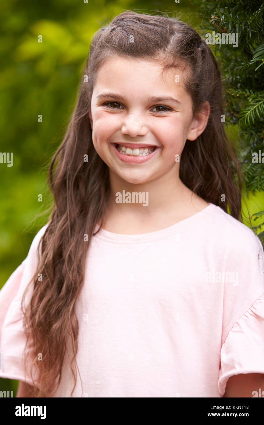 Ritratto di giovane sorridente ragazza in piedi all'aperto in giardino Foto Stock