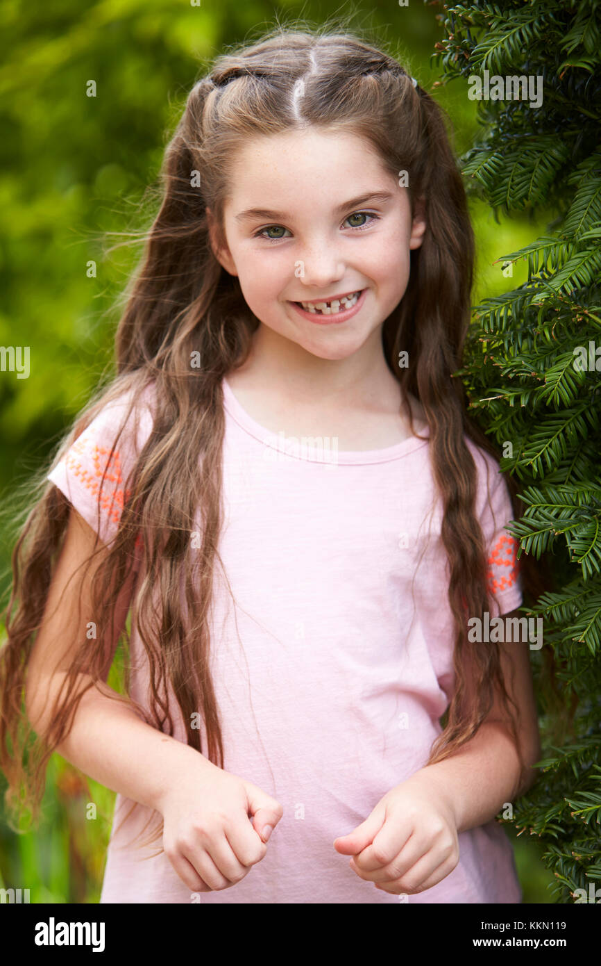 Ritratto di giovane sorridente ragazza in piedi all'aperto in giardino Foto Stock