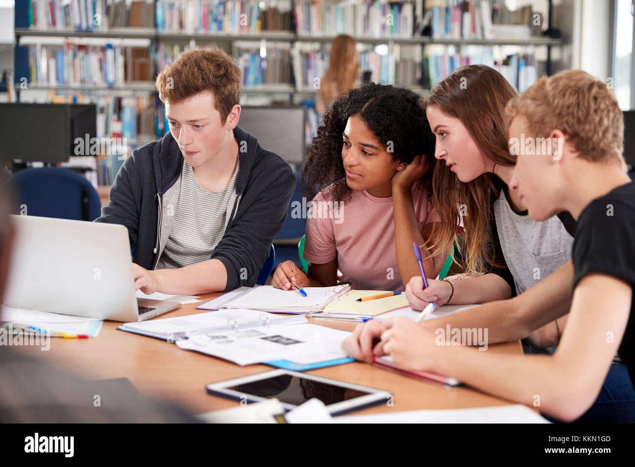Un gruppo di studenti del college di collaborare su Progetto in biblioteca Foto Stock