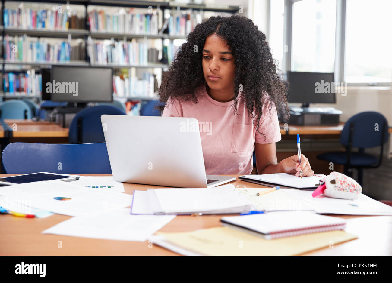 Studentessa lavora al computer portatile in College Library Foto Stock
