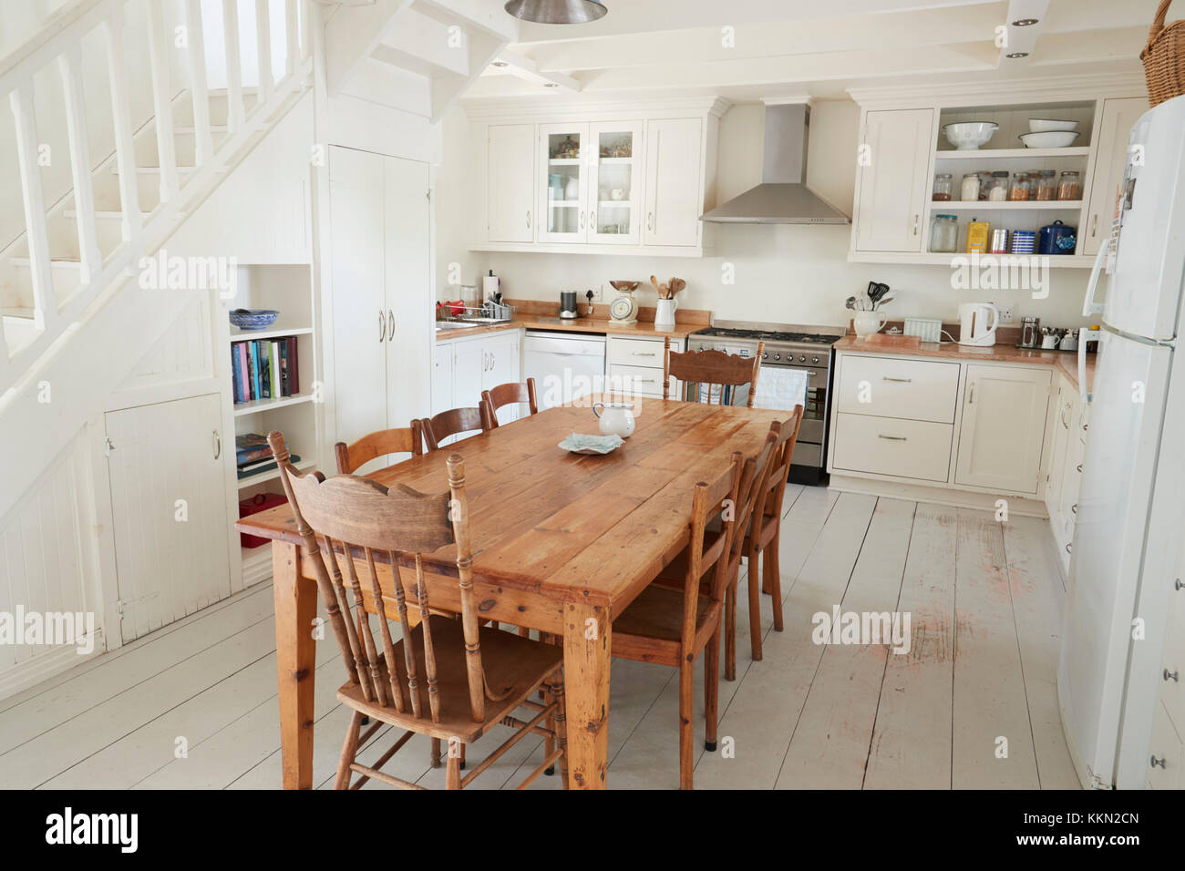 Vista interna di cucina con tavolo da pranzo in legno Foto Stock