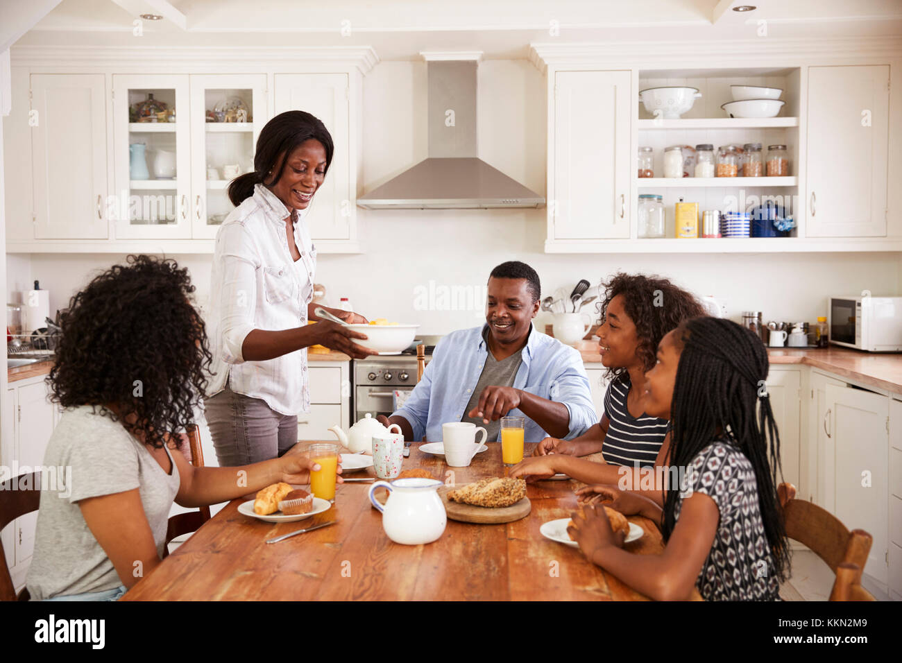 Famiglia con figli adolescenti di consumare la colazione in cucina Foto Stock