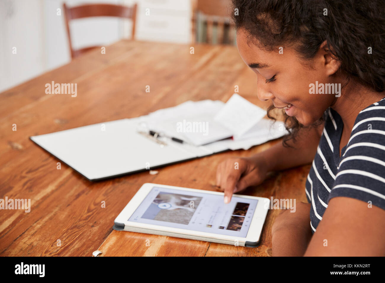 Ragazza adolescente con tavoletta digitale la revisione per l'esame a casa Foto Stock