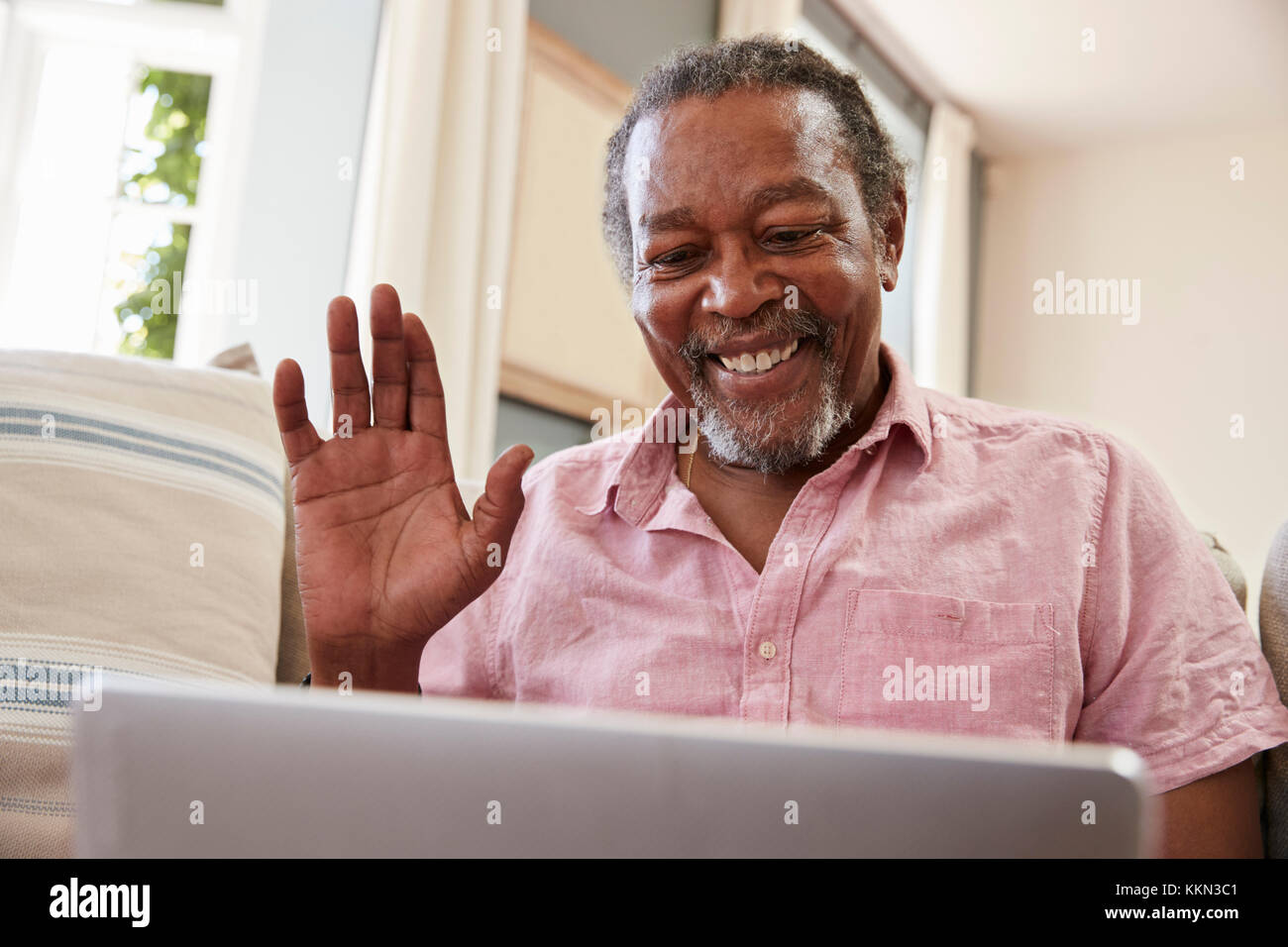 Senior uomo utilizzando laptop di connettersi con la famiglia per la video chiamata Foto Stock