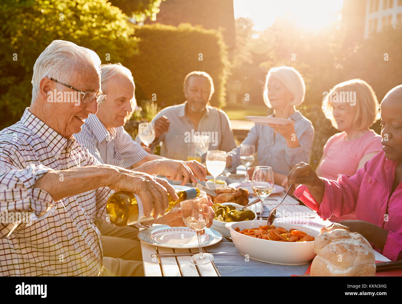 Gruppo di alti amici gustando una cena all'aperto parte a casa Foto Stock