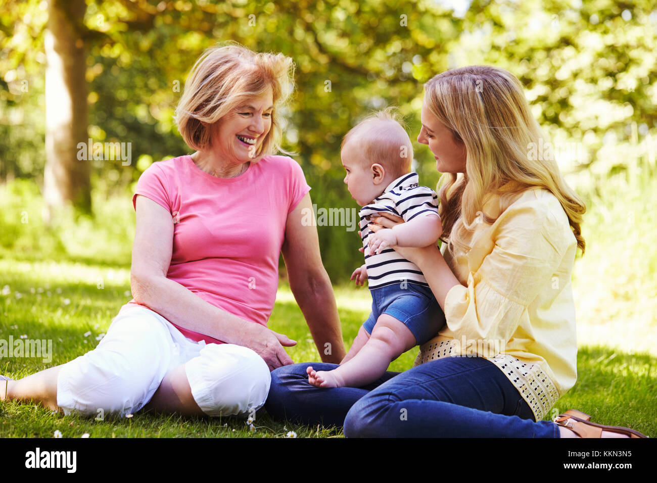 La nonna e la madre gioca con il bambino figlio all'aperto in giardino Foto Stock