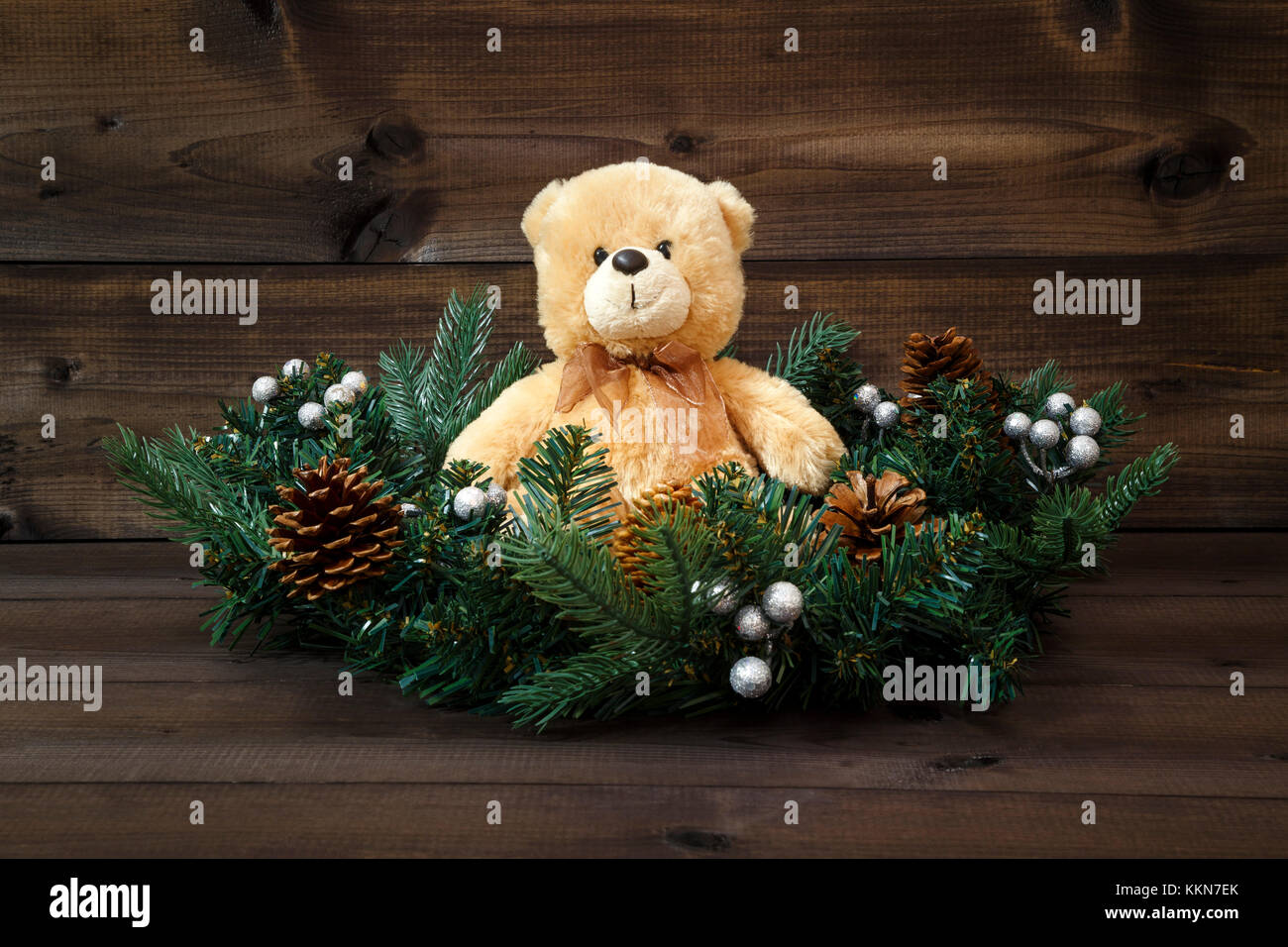 Decorate corona di Avvento con un orsacchiotto di peluche su un sfondo di legno. Foto Stock
