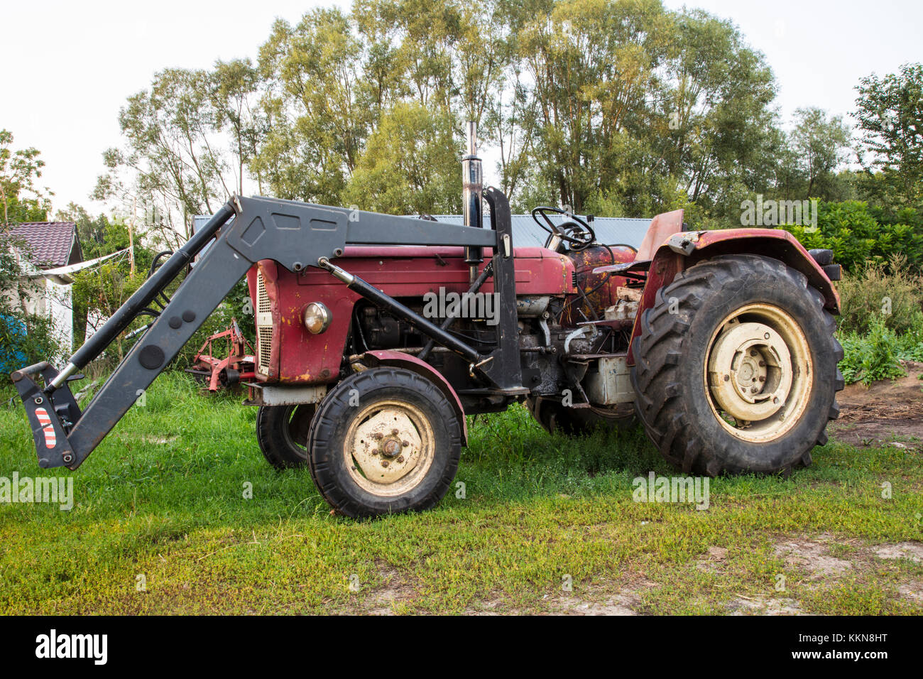 Trattore agricolo, sorge nel cortile, vecchia macchina Foto Stock