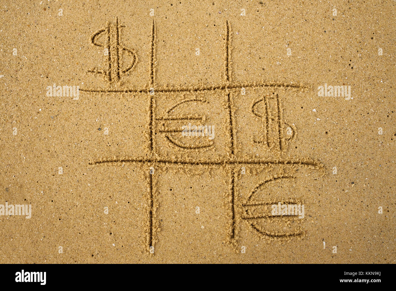 Tic-tac-toe gioco con riproduzione di euro e dollaro simboli sulla sabbia. Foto Stock