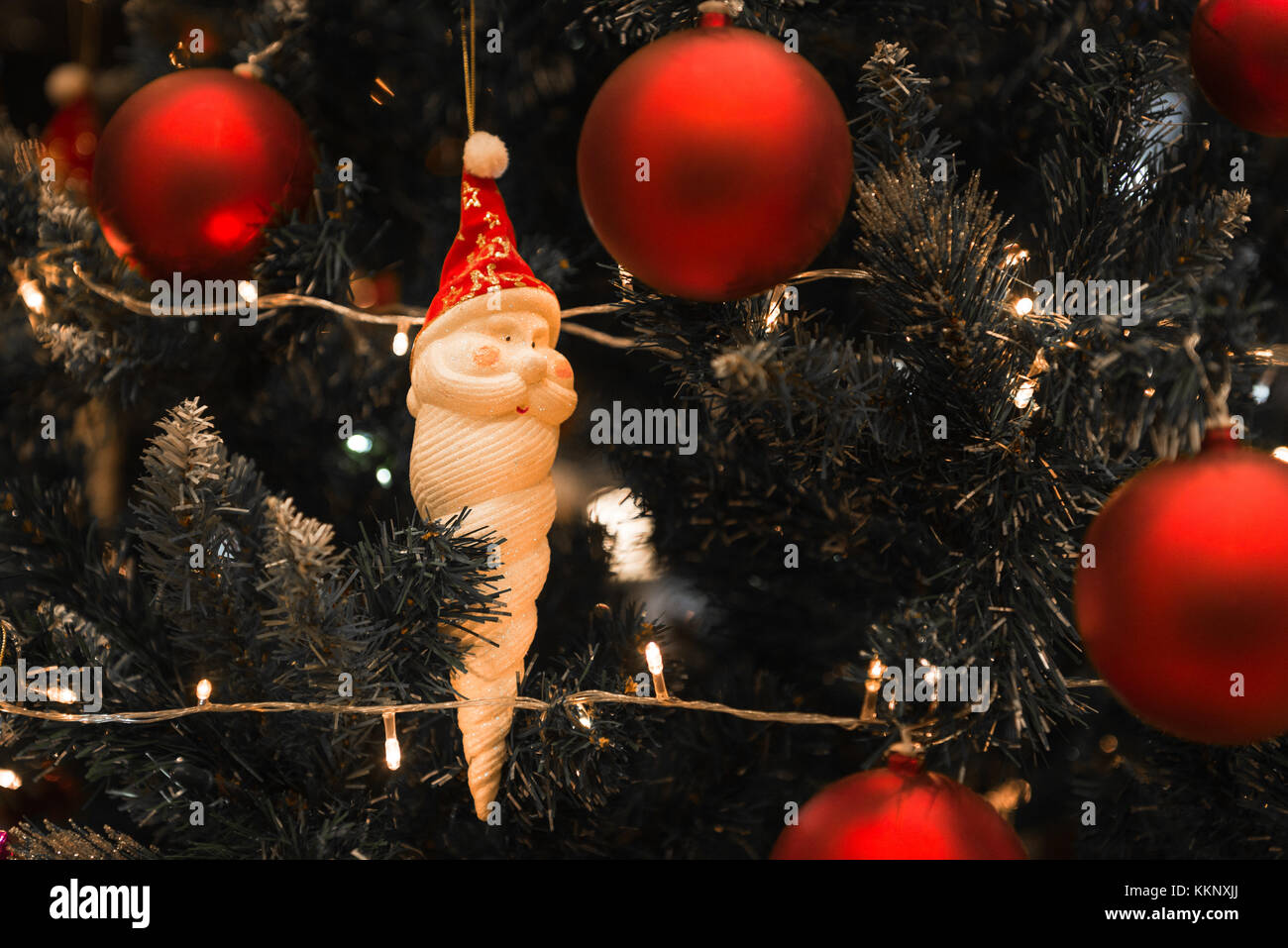 Christmas Santa Claus con lunghi orso bianco sorridente appeso su un bellissimo albero di natale circondato da red splendenti sfera Foto Stock