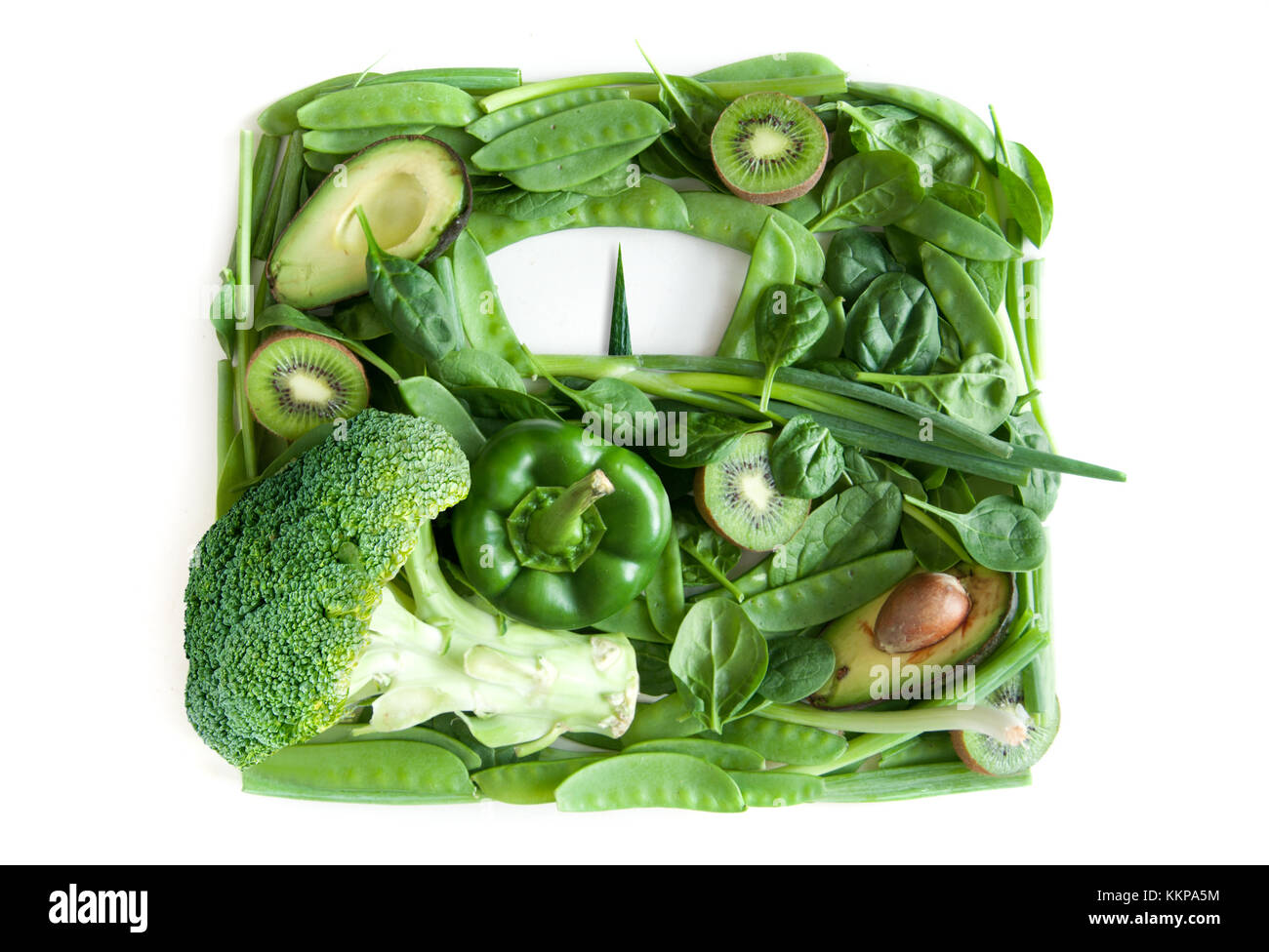 Il verde di frutta e verdura in forma di bagno bilance di pesatura su uno sfondo bianco Foto Stock