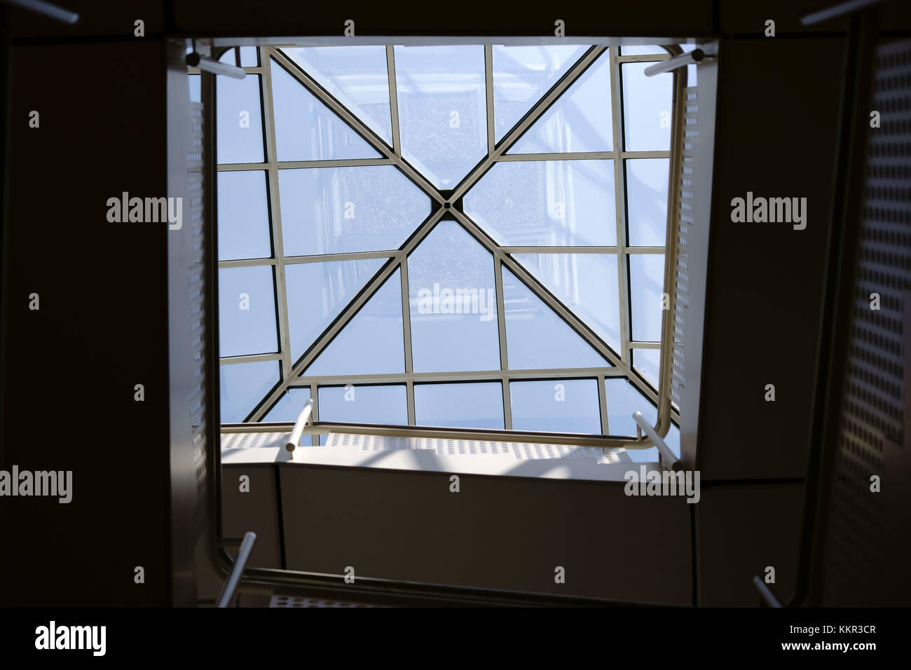 La vista inferiore delle scale che si innalzano con una scala a chiocciola angolare e ringhiera. Foto Stock