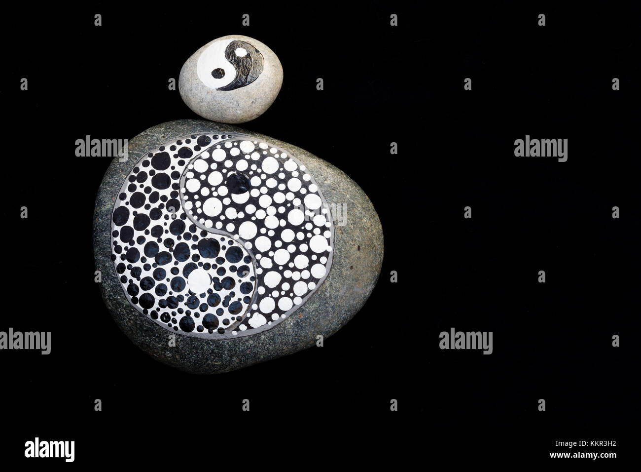 Pietre dipinte, yin e yang in bianco e nero, arte in pietra Foto Stock