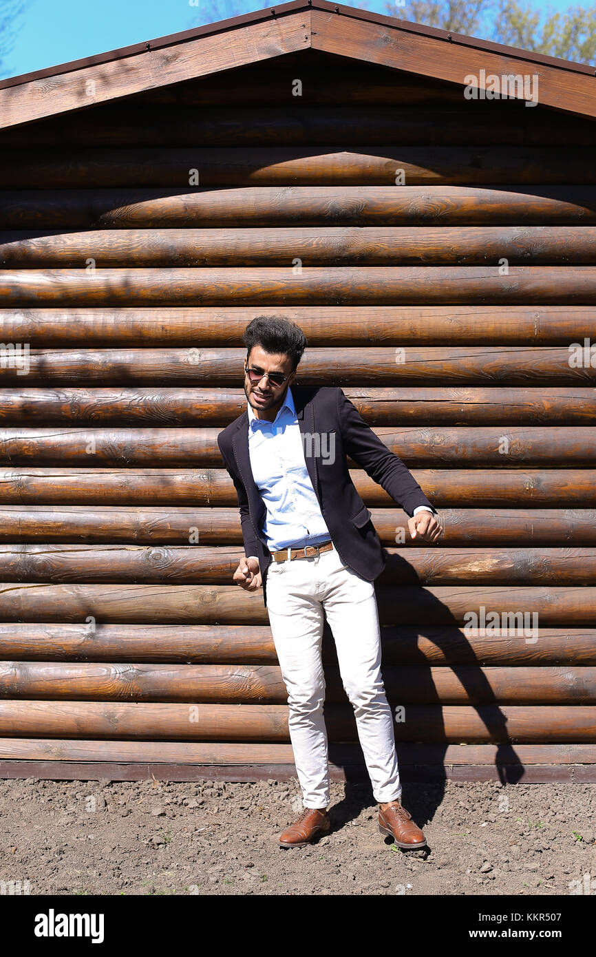 Uomo bello ballare e cantare canzoni. boy vestito in giacca nera, bianco  jeans e maglietta blu,