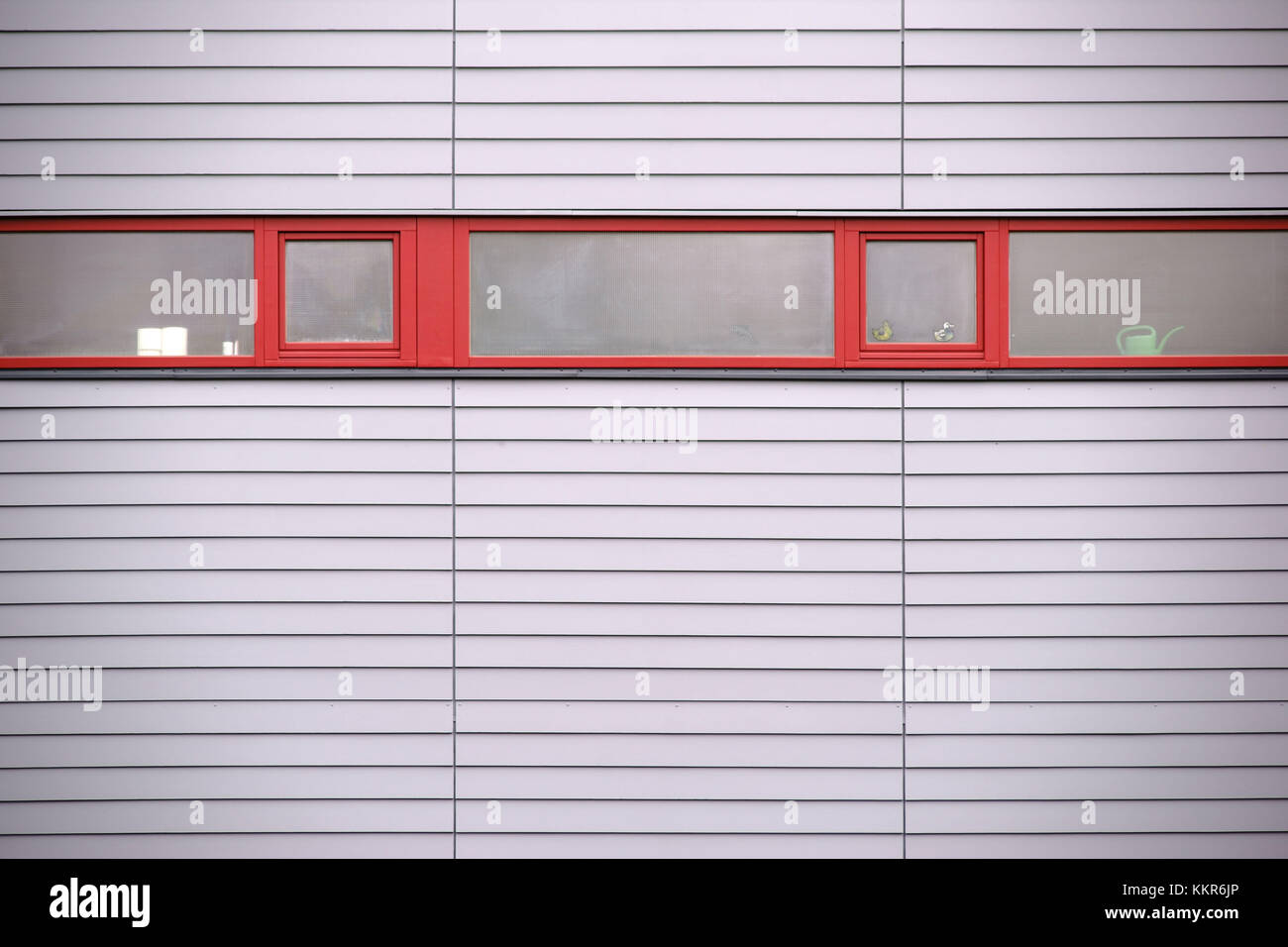 Le strette finestre di un edificio moderno con un moderno rivestimento parete. Foto Stock