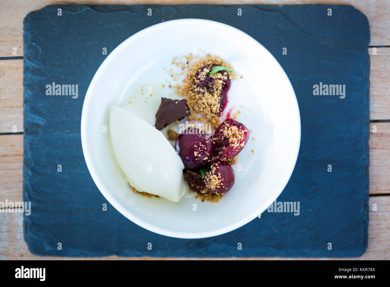 La mise en place di un dessert con mousse ghiacciata, nocciole croccanti e le ciliegie della provincia di Bolzano, Alto Adige, trentino alto adige, italia Foto Stock