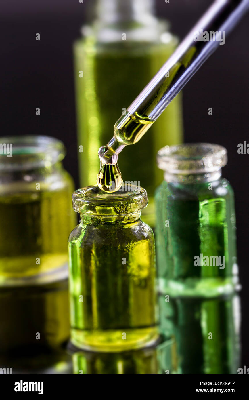 Organico puro aroma di olio essenziale in una bottiglia di vetro isolato su sfondo nero in un trattamento di bellezza. olio fragrante spa concept wellness impostazione Foto Stock