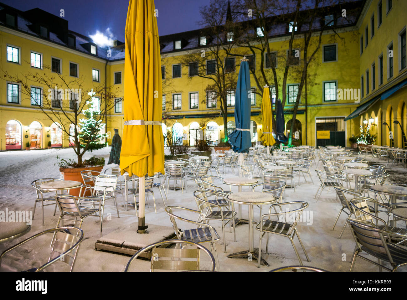 In Germania, in Baviera, Monaco di Baviera, funf hofe lussuoso shopping centre, outdoor cafe sotto la neve, sera Foto Stock