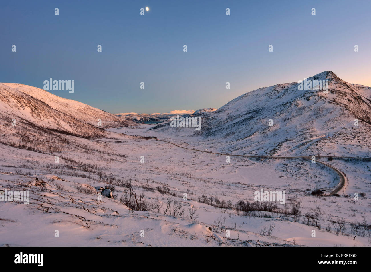 Cielo rosa al tramonto sul paesaggio innevato e congelate di mare circostante Fjordbotn Lysnes Senja Tromsø Norvegia Europa Foto Stock