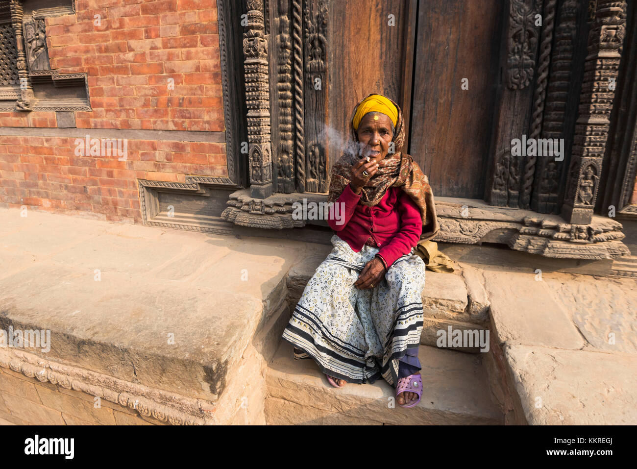 Patan Durbar Square, Kathmandu, Nepal donna fuma in patan square Foto Stock Patan Durbar Square, Kathmandu, Nepal donna fuma in patan square Foto Stock