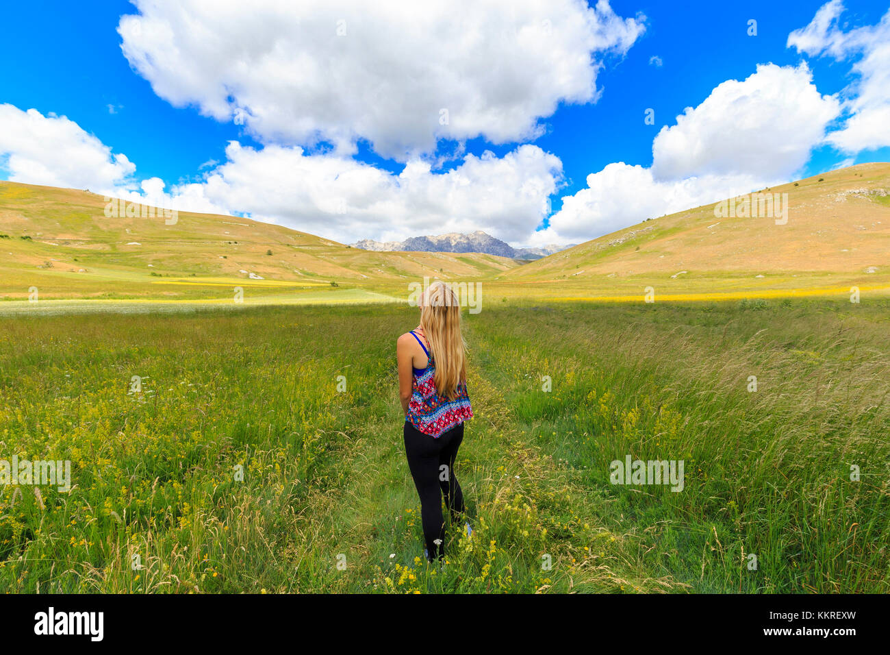 Giovane ragazza guarda le nuvole sopra i campi di santo Stefano di Sessanio, Abruzzo, Italia. Foto Stock