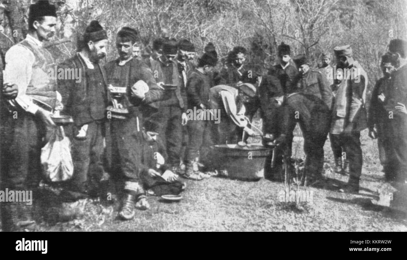 Una fotografia del 1914 raffigurante i riservisti serbi che razionano il pranzo durante la prima guerra mondiale, illustrando le difficoltà affrontate dai soldati durante il conflitto. Foto Stock