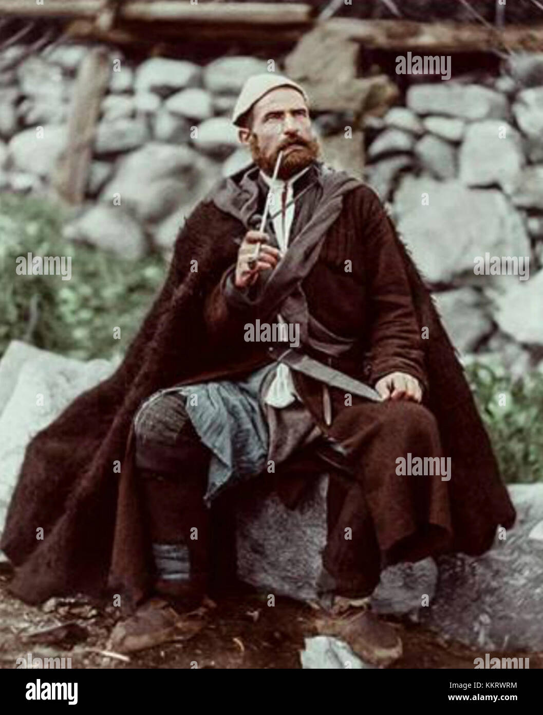 L'immagine mostra un contadino anziano di Mestia, situato a Svanetia, Georgia, con un pugnale e un lungo tubo fumante. Questa fotografia cattura una figura tradizionale, che riflette il patrimonio culturale e lo stile di vita della regione. Foto Stock