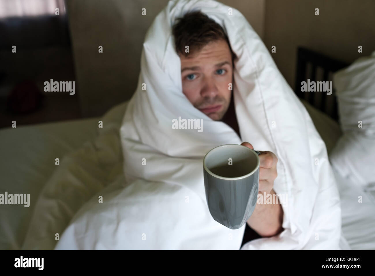 Maschio caucasico con la mancanza di sonno perché ha influenza stting nel letto e chiedere acqua o medicina Foto Stock