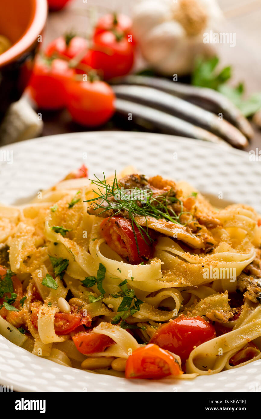 Regionale italiana piatto a base di pasta con le sarde sul tavolo di legno Foto Stock