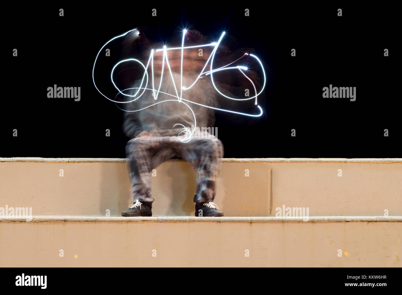 Una persona che crea una firma effettuata con la tecnica della pittura di luce. Foto Stock