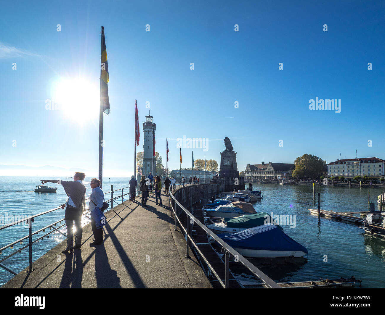Persone gustano un giorno di sole a lindau Harbour Foto Stock
