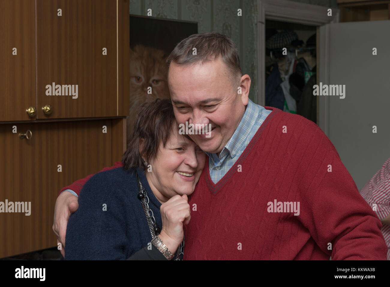 Testa e spalle in camera ritratto di anziani senior donna con capelli castani in blu scuro maglione che è snuggling fino alla sua amica in rosso il ponticello sho Foto Stock