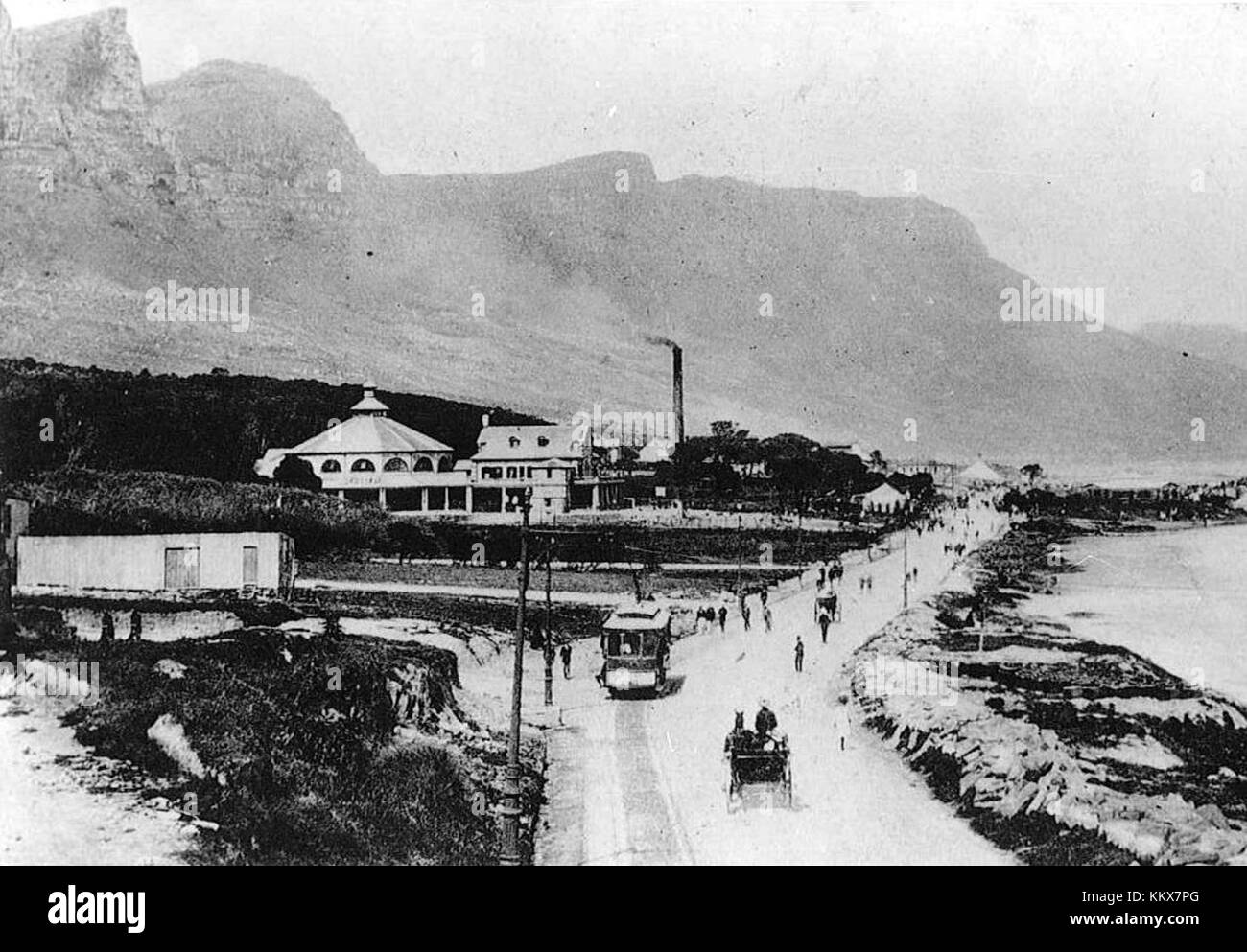 Victoria Road a Camps Bay, città del Capo, Sud Africa, intorno al 1903, descrive lo sviluppo iniziale dell'area. La fotografia mostra gli inizi di quella che sarebbe diventata una delle principali destinazioni turistiche, catturando le prime fasi dello sviluppo urbano di questa pittoresca regione. Foto Stock