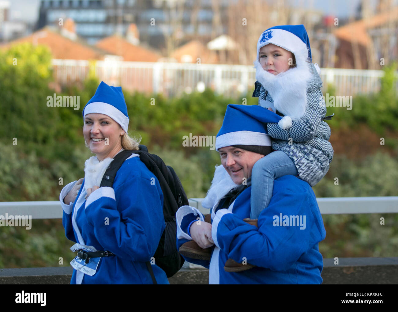 Abiti di Natale Evertoniani Blue White a Liverpool, Merseyside, Regno Unito, dicembre 2017. Il campo BTR Liverpool Santa Dash inizia e termina nel centro di Liverpool con un percorso stradale di 5 km che inizia al Pier Head su Canada Boulevard di fronte agli edifici Liver. Lo spettacolo festivo con migliaia di Santas che corrono per divertirsi in giro per le strade è aperto a corridori, jogging e camminatori, ma tutti devono prendere parte alla Santa Suit fornita in rosso per il Liverpool FC o in blu per l'Everton FC. Foto Stock