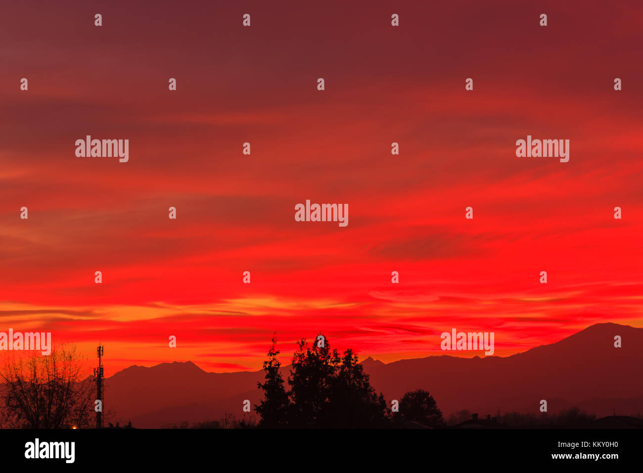 Il sole era molto basso oltre l'orizzonte e i suoi raggi attraversando l'atmosfera è aumentato il colore rosso del cielo /un tramonto spettacolare dipinge il cielo Foto Stock