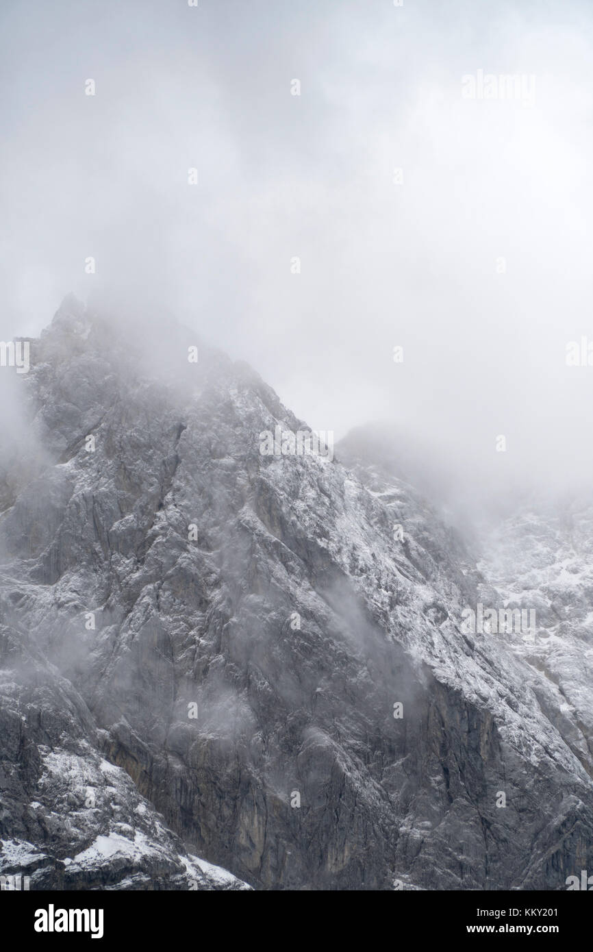 Massicce montagne innevate avvolto in nubi Foto Stock